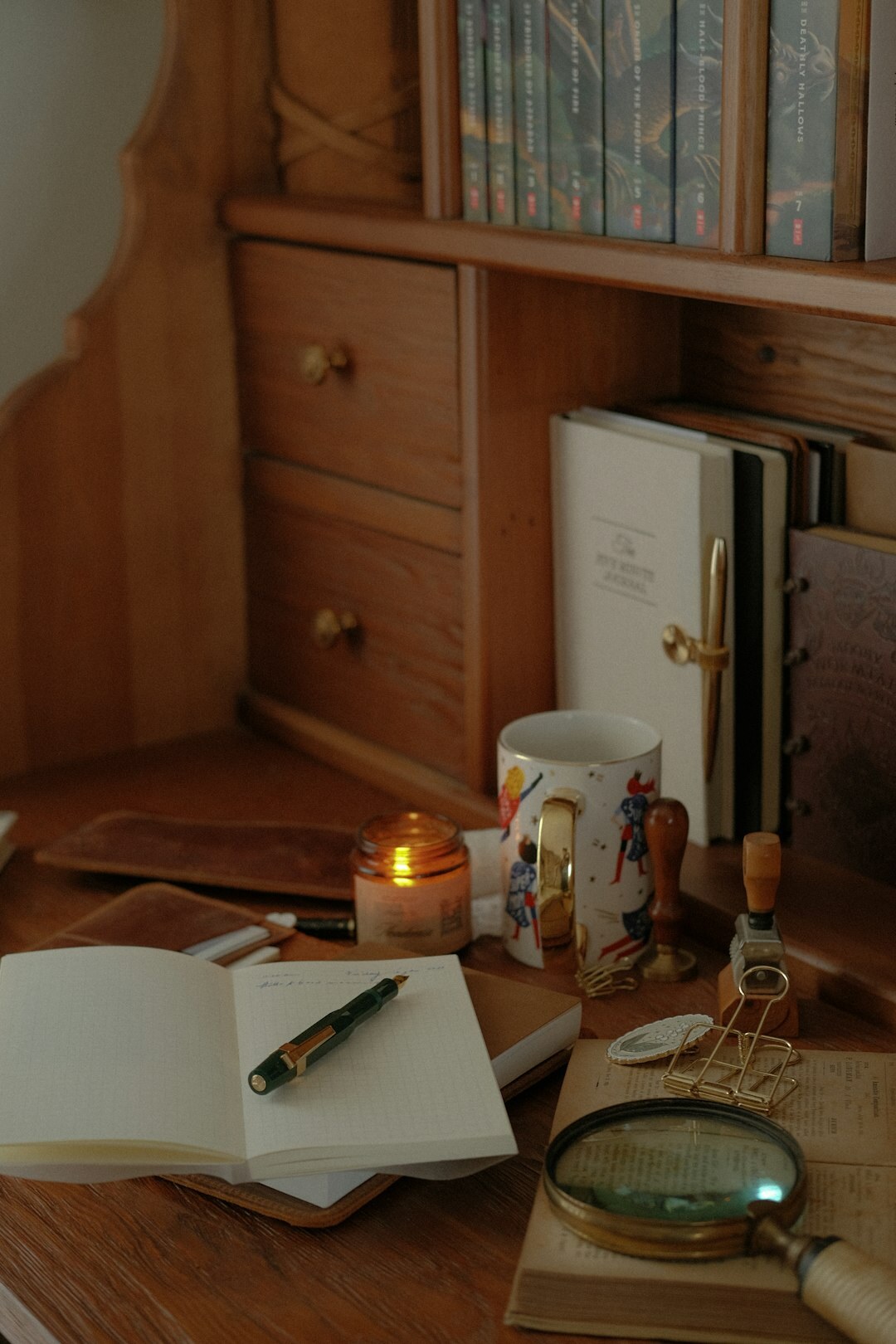 Person writing in a journal at a wooden desk