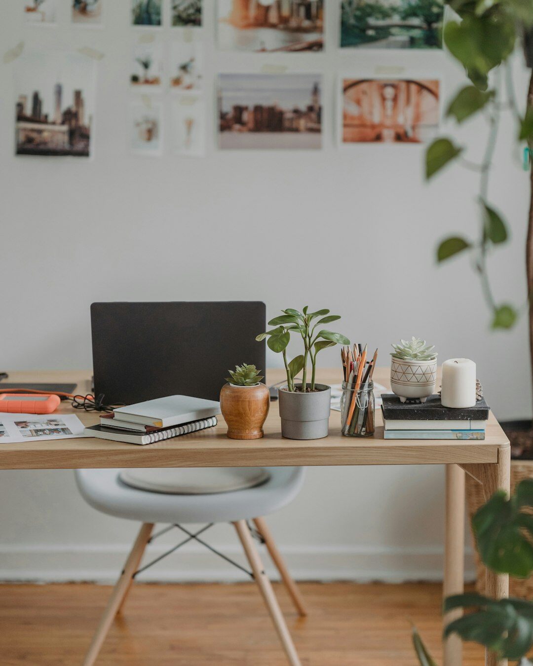 Woman writing notes at a desk with plants nearby