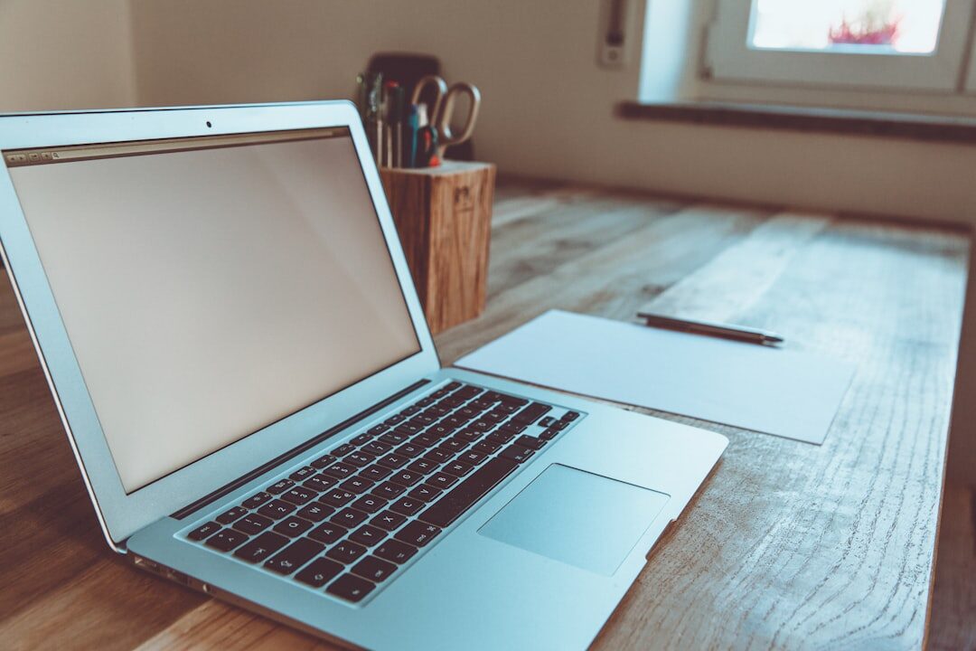 Person typing a message on a laptop at a bright desk